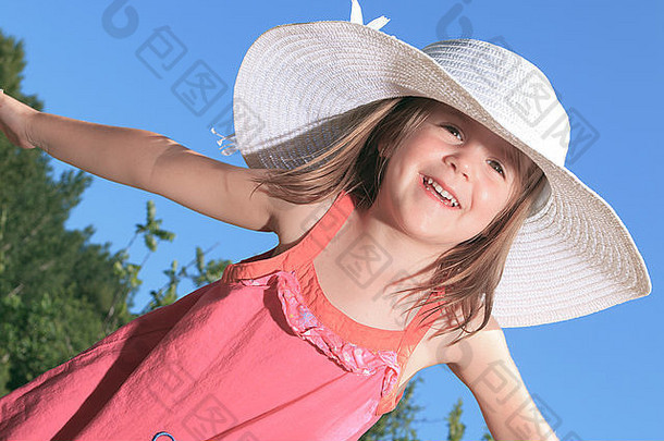 在公园外面戴着花园帽子的小女孩