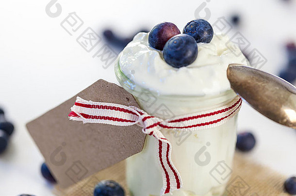 Jar凝结的奶油酸奶新鲜的蓝莓系装饰丝带空白礼物标签Copyspace