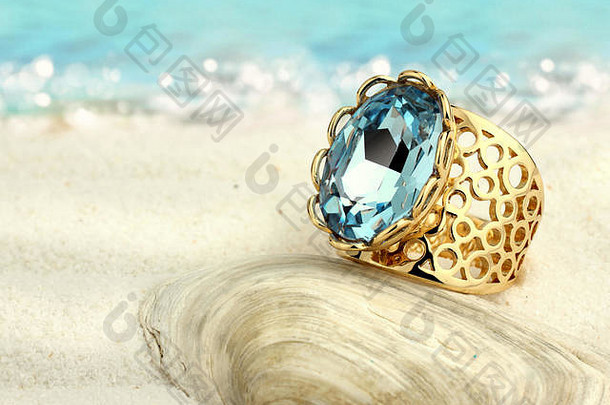 夏日沙滩上的金戒指和海蓝宝石