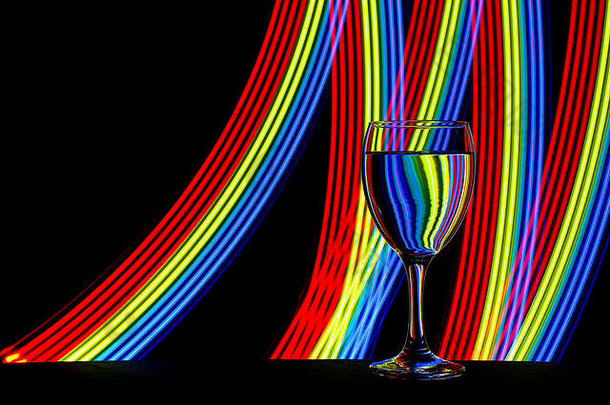 酒玻璃眼镜孤立的黑色的背景色彩斑斓的条纹霓虹灯光绘画