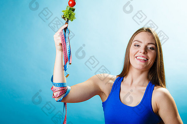 苗条的身体概念年轻的女人适合女孩素食者食物测量磁带蓝色的背景工作室