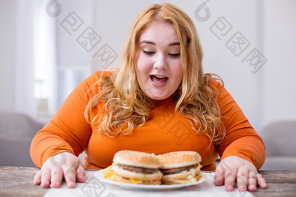旺盛的脂肪女人吃薯条三明治