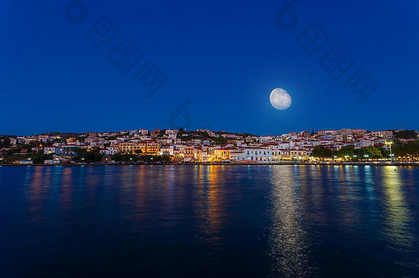 位于希腊南部的皮洛斯镇的全景，月亮在城市上空，在黄昏时拍摄，月亮从天空升起