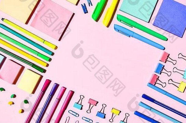 粉红色背景上的不同办公用品或学校用品。文本的空间