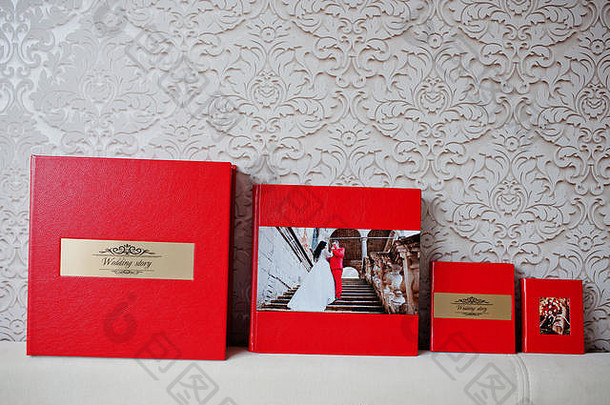 优雅的红色婚礼相册或相册，在柔和的蜡笔背景上刻有金色铭文。