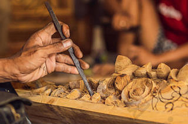 木雕大师用一把特殊的刀制作了一道木制民族菜——一个有图案把手的勺子。他手上旗帜特写镜头的碎片