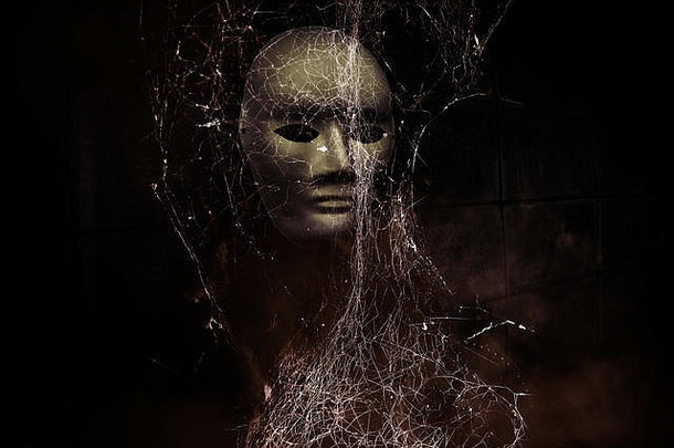 神秘的黑衣女人戴着白色面具藏在蜘蛛网后面，<strong>书的封面</strong>背景很恐怖