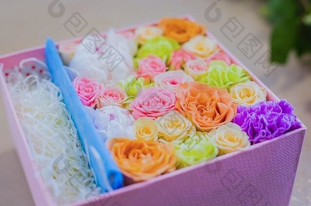 花卉、工艺、手工制作、婚礼、生日、庆典概念。带有五颜六色花朵的礼盒特写视图-桌上的玫瑰、牡丹、康乃馨