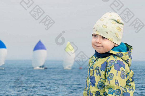 小男孩海边看赛船会