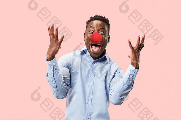 年轻快乐男子庆祝红鼻子日的肖像。以粉色工作室为背景的非洲男模特看起来很惊讶。胜利，快乐的概念。人类面部情绪，表情概念。时髦的颜色。