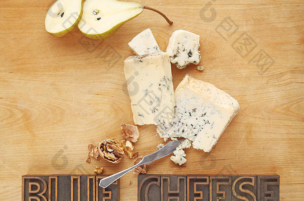 蓝色乳酪片配新鲜梨、胡桃和带有复印空间的砧板上的文字
