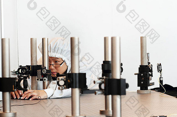 一位亚洲女科学家正在一个全息实验室里工作，她的无尘外套了新技术
