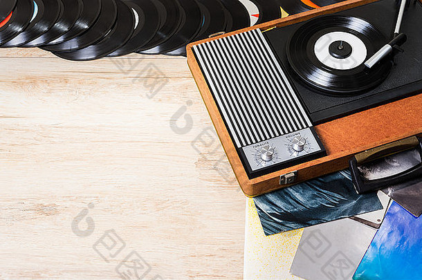 木制桌子、顶视图和复印空间上带有乙烯基唱片的留声机。