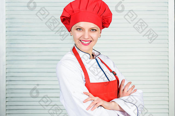 有厨具的家庭主妇。厨房里的专业厨师。烹饪戴厨师帽和围裙的女人。快乐女人用食谱烹饪健康食品。要求送货。