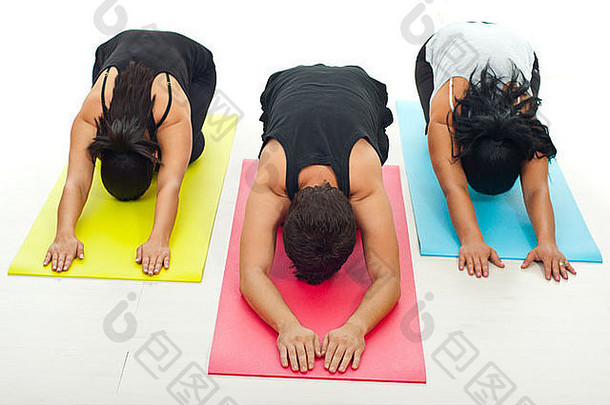 三人一组在五颜六色的体操垫上做瑜伽练习