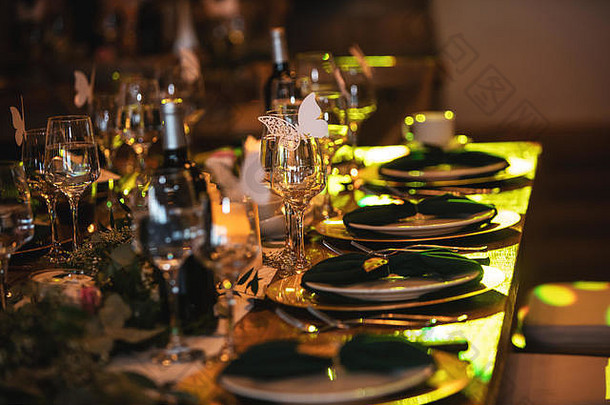 接待餐桌的复古装饰。在豪华的欧洲餐厅，乡村婚礼餐桌的摆设。酒杯、盘子、叉子和绿三角裤