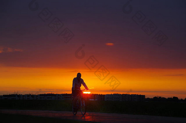 轮廓男人。自行车城市不错的日落背景