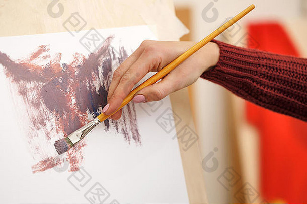那个女孩在艺术学校画抽象画。双手特写。成人绘画课程。