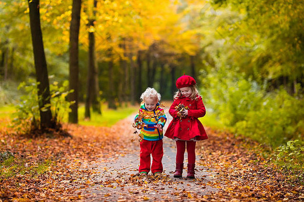 孩子们玩秋天公园孩子们玩在户外阳光明媚的秋天一天男孩女孩运行手手森林