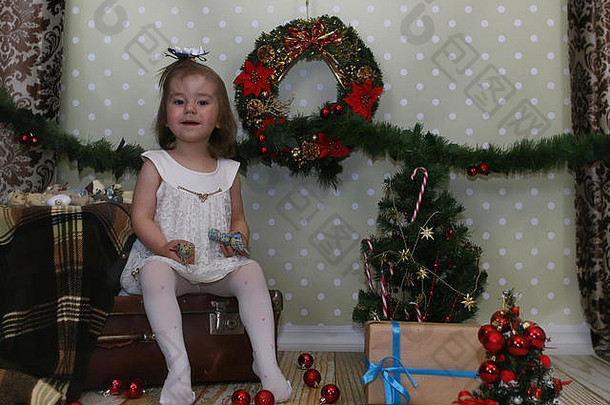 女孩坐着前面圣诞节树