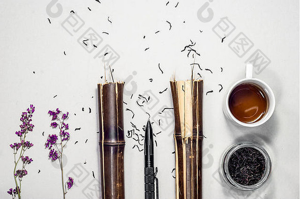 植物标本室的紫罗兰花，碎竹竿，一支笔，一杯茶，一罐干茶。平铺合成