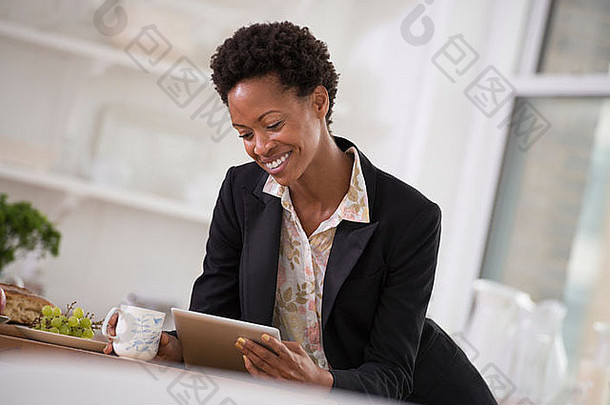 商人。一位穿着<strong>黑色夹克</strong>的女士正在使用数码平板电脑。
