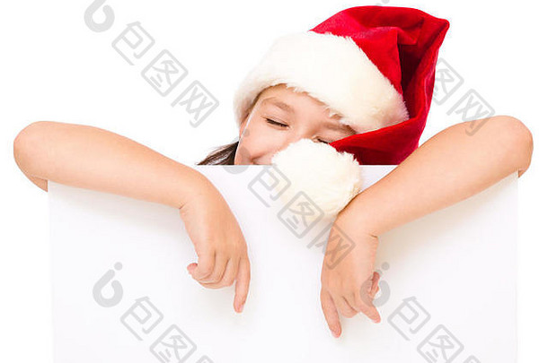 戴圣诞帽的小女孩拿着白板，用食指指着白板，闭上眼睛，隔着白板