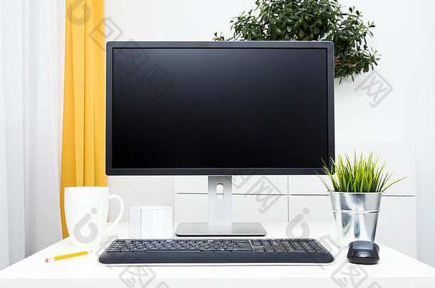 桌面上的空白显示器和办公配件，内部明亮