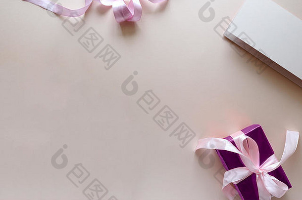 白色和紫色郁金香的花束，粉红色背景上的礼品盒和空白纸。顶视图。平铺。空间。情人节、母亲节、生日