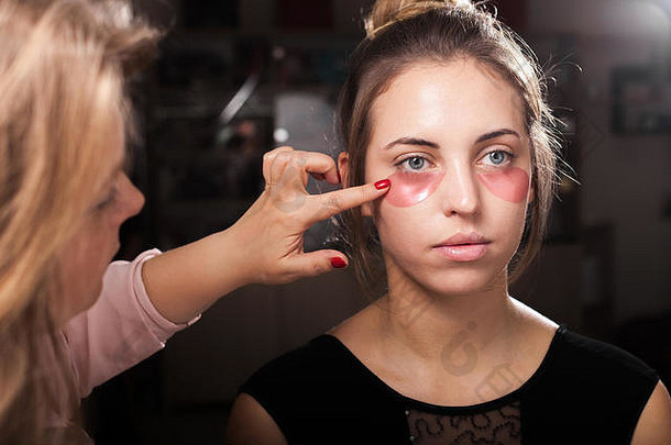 化妆师在女孩身上涂水凝胶眼罩