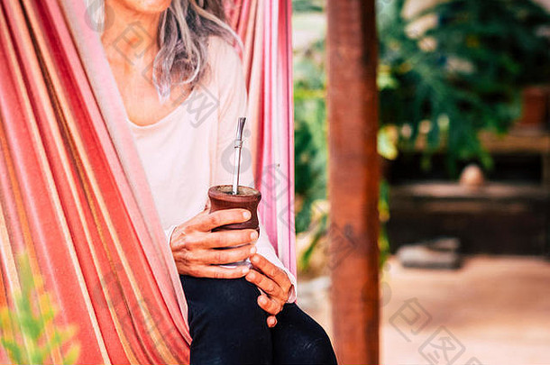 关闭自然健康的替代瑜伽高加索人女人喝自然茶坐着吊床放松享受户外放松休闲activi