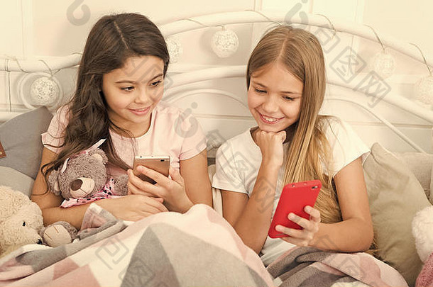 祝你节日愉快。通过手机发<strong>送</strong>圣诞和<strong>新年</strong>祝福短信。快乐的孩子们用手机。小女孩在床上使用智能手机。圣诞快乐，<strong>新年</strong>快乐。
