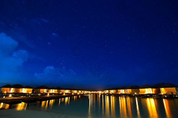 马尔代夫热带岛屿度假胜地的水上别墅，夜晚星光灿烂。
