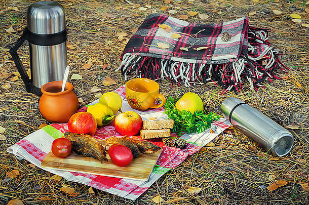 秋天森林快乐桌布准备野餐水果蔬菜炸鱼咖啡热水瓶附近的
