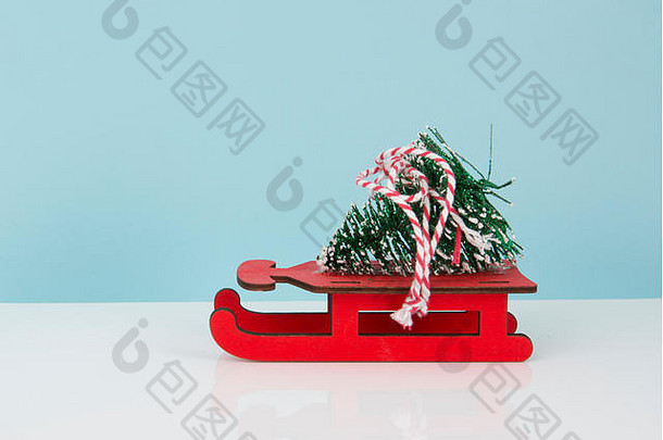 红色木制雪橇上的玩具圣诞树，带有空间