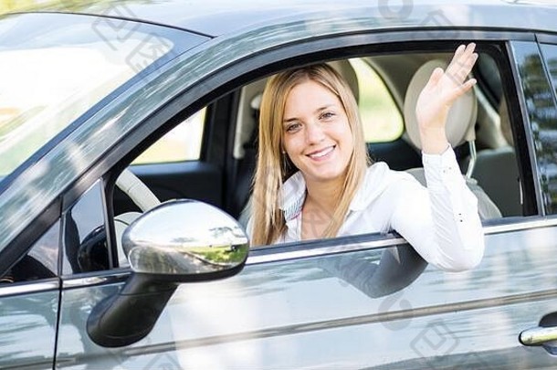 一位风度翩翩、笑容可掬的年轻女子正坐在一辆新车上