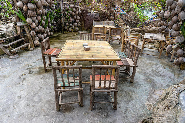 花园里海边空荡荡的海滩咖啡馆里的木制桌椅。闭合。泰国高潘根岛
