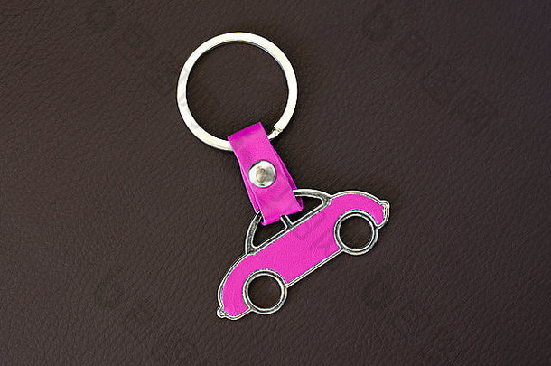 钥匙链黑色皮革垫上的粉红色汽车