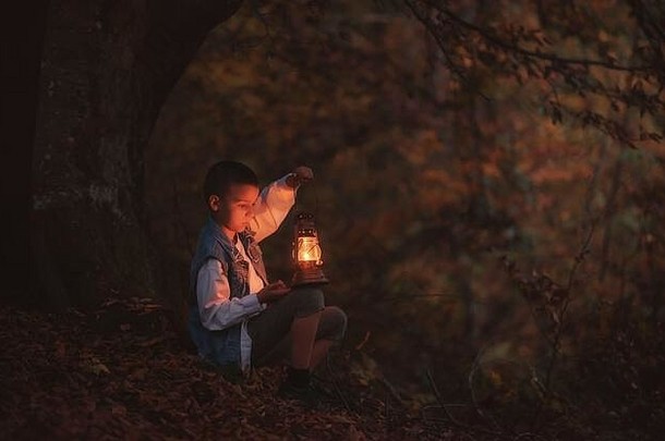 在世界末日般的环境中，迷路的孩子手里拿着一盏旧灯