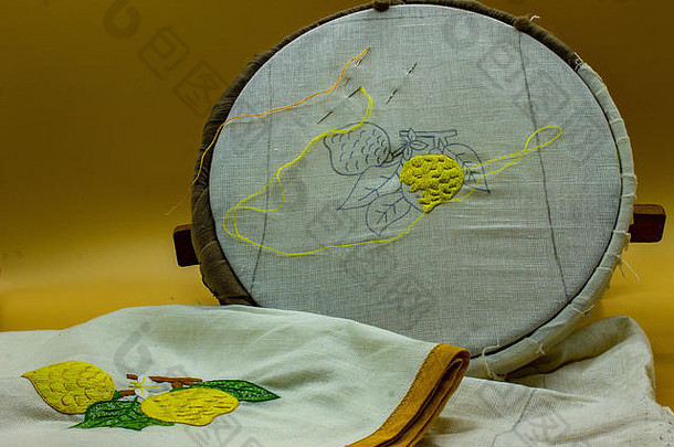 意大利那不勒斯，2019年4月21日。缝纫工具、针、线。在画框上可以看到画布上绣着柠檬，最后它会