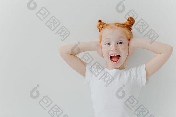 情绪化的红发女孩张<strong>大嘴巴</strong>，捂住耳朵，为嘈杂的气氛而兴奋，穿着白色休闲t恤，对一些事情做出情绪化反应
