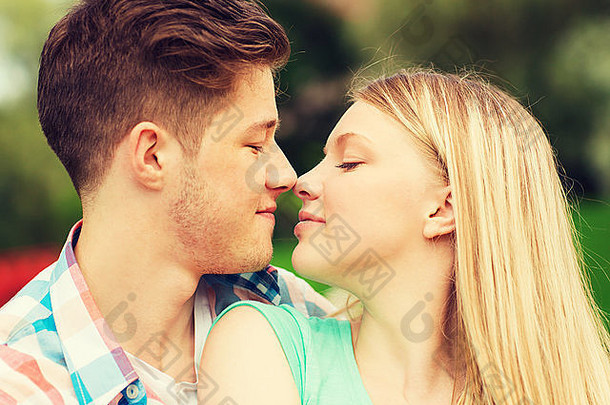 公园里一对微笑的夫妇抚摸着鼻子