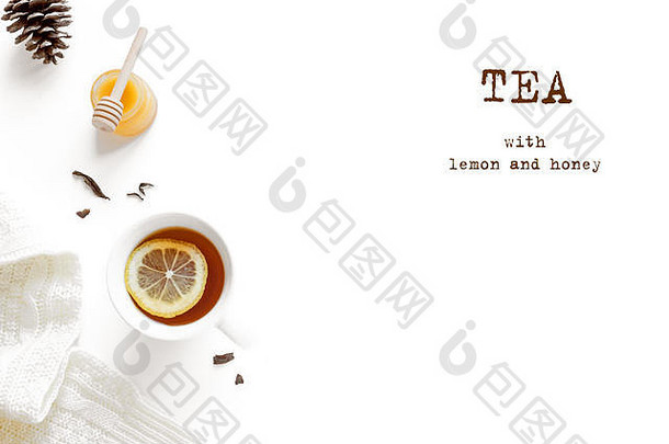 一杯柠檬蜂蜜茶，温暖的白色毛衣，松果和白色背景上隔离的干茶叶。舒适的冬季构图-红茶