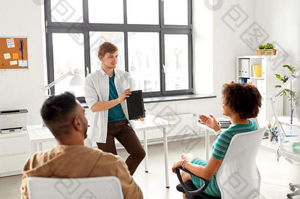 男子在办公室向创意团队展示平板电脑