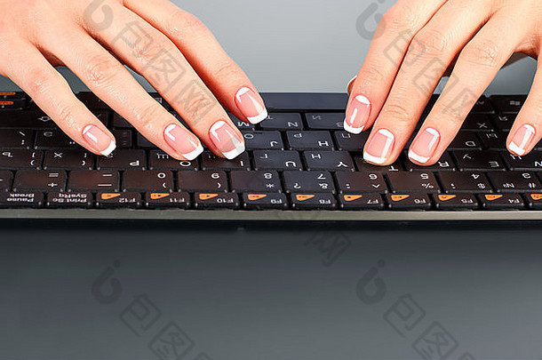 女人的手指在无线键盘上。