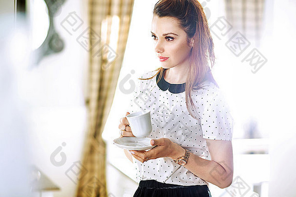 漂亮的年轻的女人喝<strong>咖啡</strong>