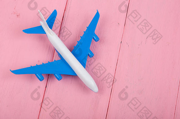 粉色木制背景上的玩具飞机。俯视图