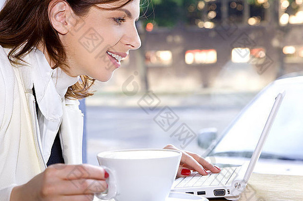 快乐的女商人早上喝咖啡，<strong>上网</strong>