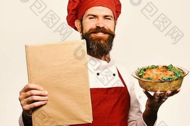 身穿勃艮第制服的厨师面带自豪的微笑，手里拿着烤好的菜肴和菜单。留着白胡子的男人。厨师端着一碗土豆沙锅菜和价目表。和烹饪服务理念。