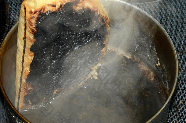 锅里的饭在一个<strong>烧开</strong>的袋子里煮，结果水煮出来了，它还在冒烟。